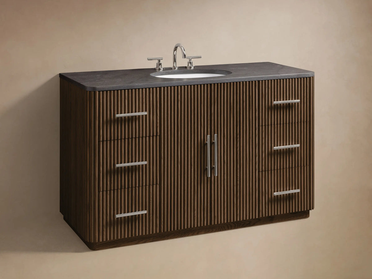 Finnley Wide Single Vanity: Close-up of dark brown ribbed wood cabinet, polished nickel bar pull, open to show shelves with box and towels.