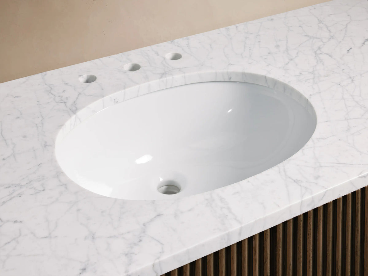 Finnley Wide Single Vanity with white oval sink, veined Carrara marble top, antique bronze faucet, slatted wood cabinet.