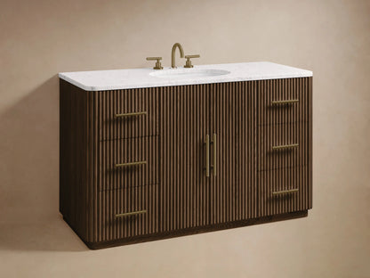 Finnley Wide Single Vanity, dark brown fluted wood, white marble top, open drawer with white towels & bottles, brass handle.