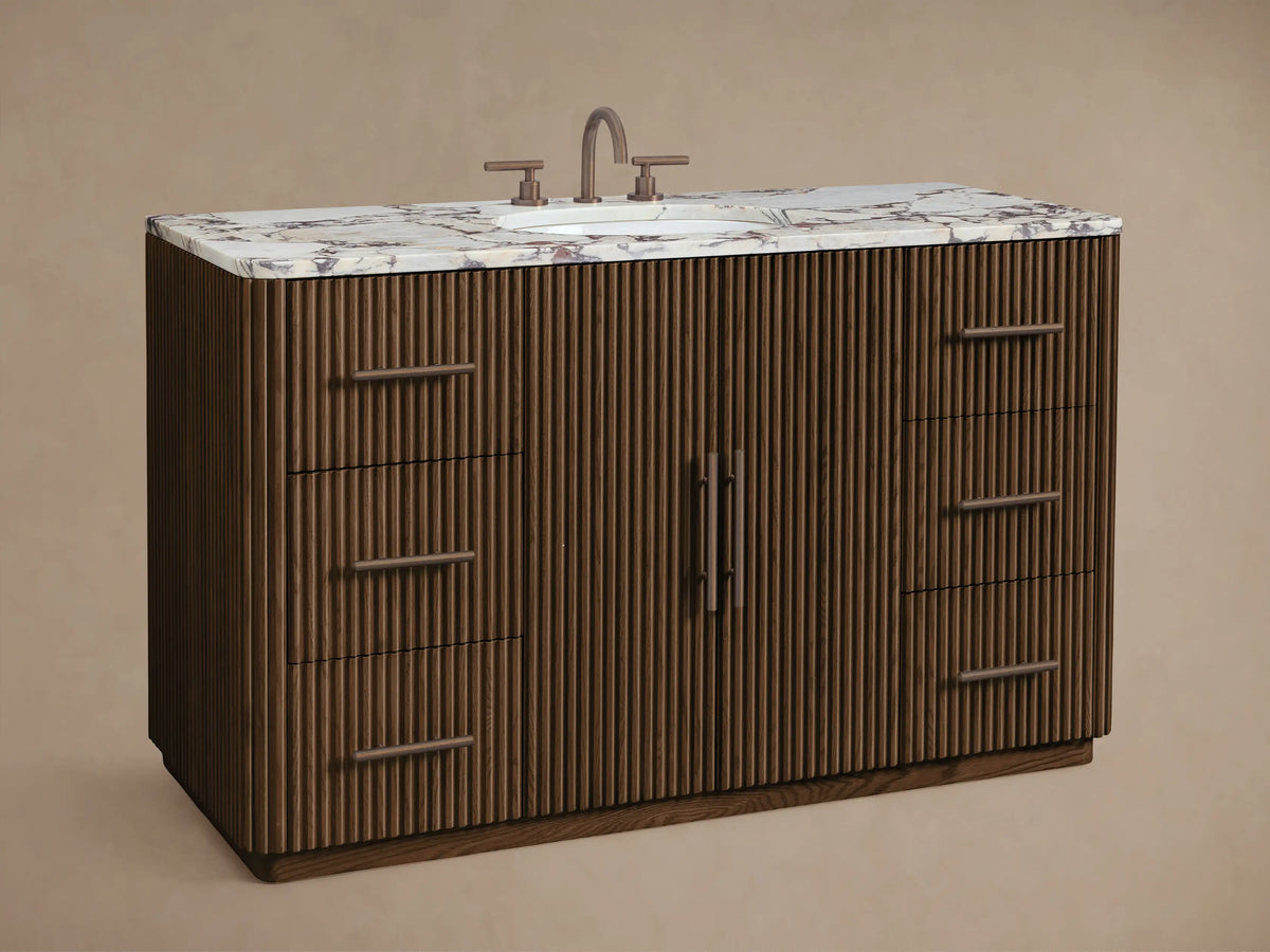 Close-up of open Finnley Wide Single Vanity cabinet. Dark fluted oak door with bronze handle, revealing shelves with white towels.