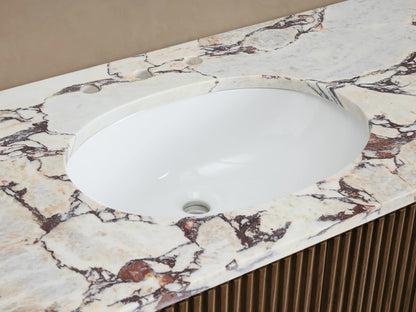 Finnley Wide Single Vanity close-up. White oval sink, white marble countertop with reddish-brown veining, brass faucet, slatted wood base.