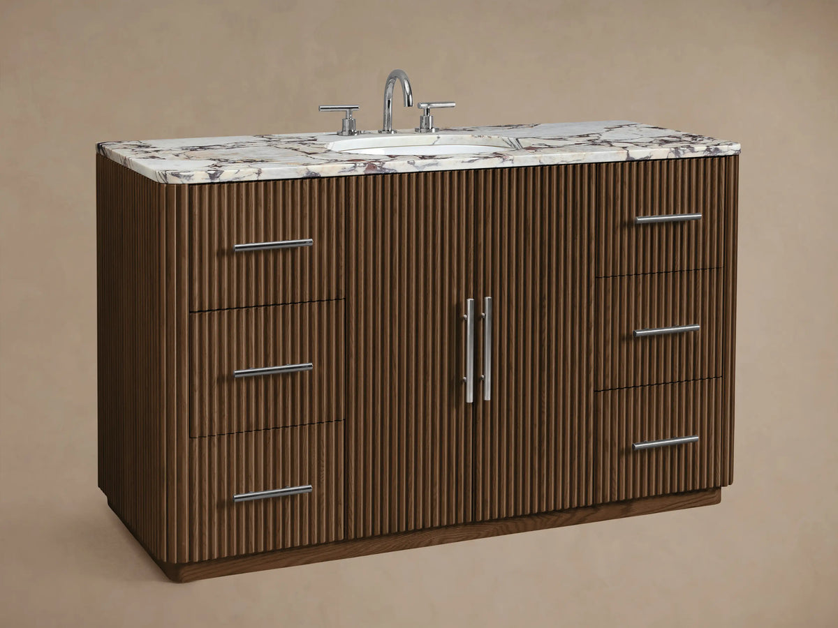 Finnley Wide Single Vanity, dark fluted wood, white marble top with oval sink. Six drawers, two doors, polished nickel pulls.