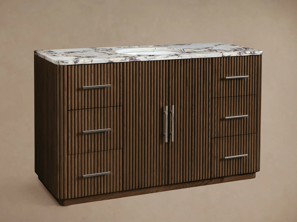 Brown ribbed wood Finnley Single Vanity with white marble top, oval sink, silver faucet, two center doors, and 6 silver-handled drawers.
