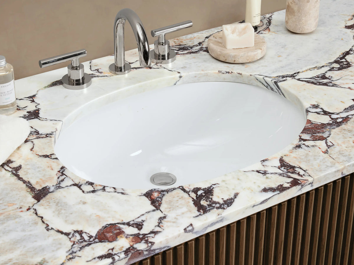 Finnley Wide Single Vanity, dark brown fluted wood cabinet with white/grey marble top, oval sink, and silver pulls.