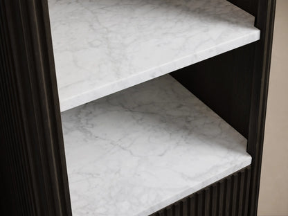 Finnley Tall Bath Cabinet, close-up. Dark fluted wood drawer open with towels. White Carrara marble shelf above with towels, soap.
