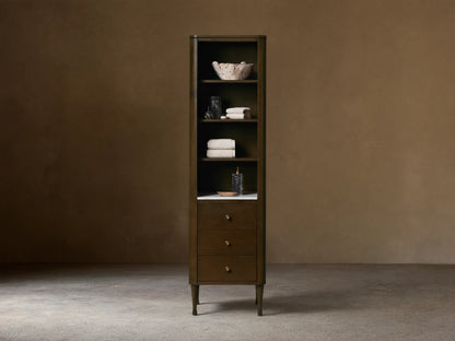 Tall Laurent Bath Cabinet, dark wood, white marble, 4 shelves with towels & decor, 3 drawers, brass pulls.