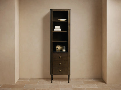 Tall Laurent Bath Cabinet in Bahasa Brown, with open shelves, black stone top, and three drawers with brass knobs.