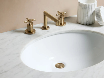 Circular pop-up drain from Lomas Faucet made of antique brass with a polished surface, set against a white background.