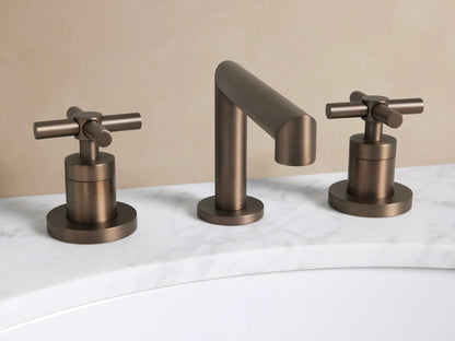 Lomas Faucet in Bronze with curved spout & 2 cross-style handles, on a white marble countertop over a white sink.