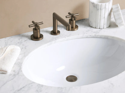 Lomas Faucet in Bronze with curved spout & 2 cross-style handles, on a white marble countertop over a white sink.