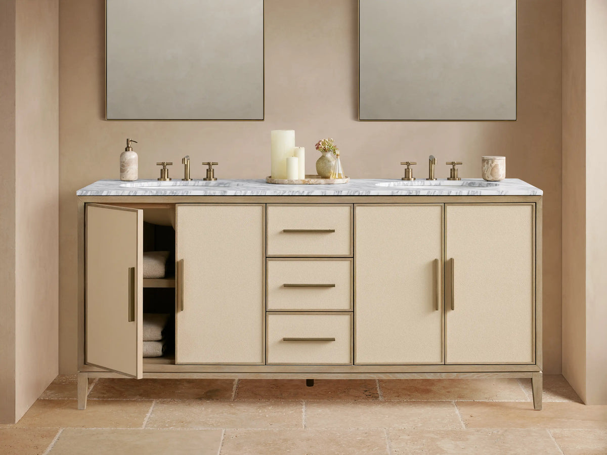 Malone Double Vanity in Bone finish. Light wood frame, cream shagreen cabinet doors & drawers with brass handles. White marble top.