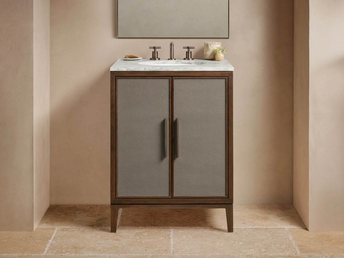 Malone Powder Vanity: Dark wood frame, gray shagreen cabinet doors, bronze handles, white marble top with faucet & sink.