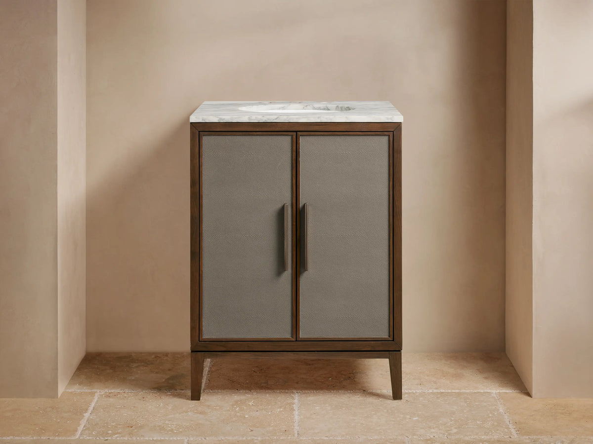 Malone Powder Vanity: Dark wood frame, gray shagreen cabinet doors, bronze handles, white marble top with faucet & sink.