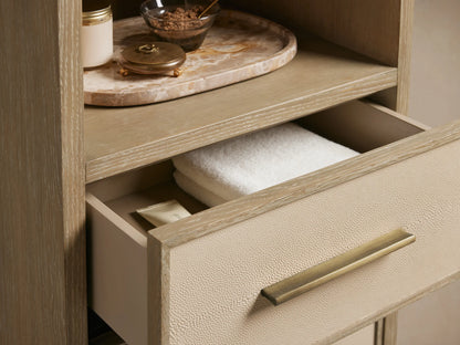 Malone Tall Bath Cabinet in bone finish oak, with 3 open shelves & 3 drawers featuring light shagreen fronts & brass pulls.