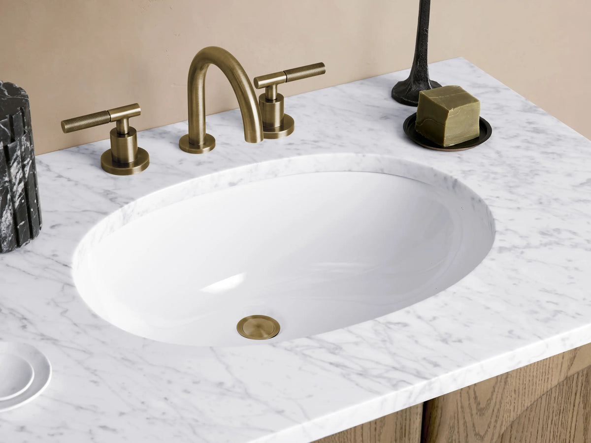 Provo Double Vanity with oak wood finish, featuring four arched-panel doors. White stone top with two oval sinks. Soft lighting.