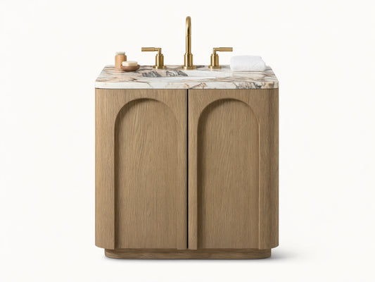 Provo Powder Vanity with oak wood finish, honed marble top, brass faucet, oval undermount sink, two arched doors, set against a neutral-toned bathroom.