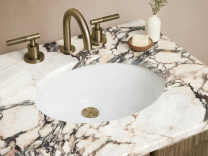 Provo Powder Vanity with oak wood finish, arched doors, marble stone top, brass faucet, on beige tiled floor.