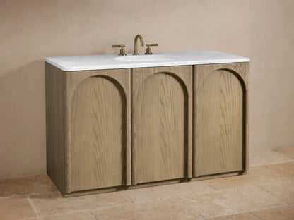 Provo Single Wide Vanity with oak wood doors, open to reveal shelves with toiletries, towels inside, marble top visible.