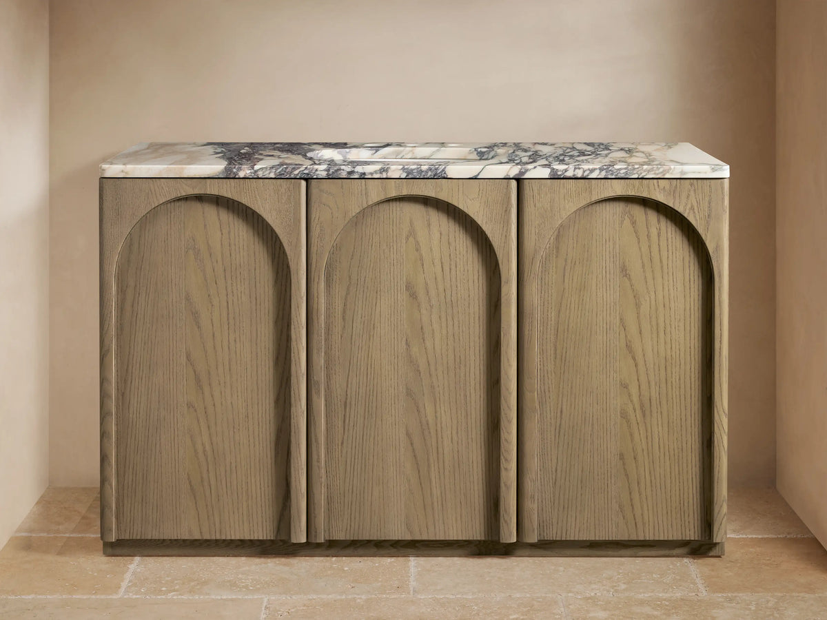 The Provo Single Wide Vanity features three oak wood panels, a marble top with veining, and a double faucet setup.