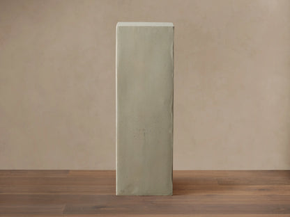 Light gray rectangular fiberglass Outdoor Pedestal standing on a dark wood floor against a beige wall.