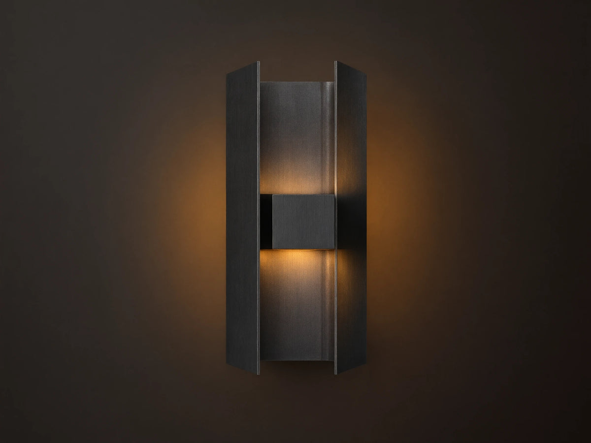Sidney Outdoor Sconce, a graphite aluminum fixture casting warm LED light up and down against a taupe wall.