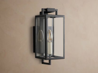 Hendricks Outdoor Sconce: black iron rectangular lantern, clear glass, two candle-style bulbs, mounted on a taupe wall.