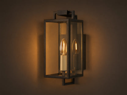 Hendricks Outdoor Sconce: black iron rectangular lantern, clear glass, two candle-style bulbs, mounted on a taupe wall.