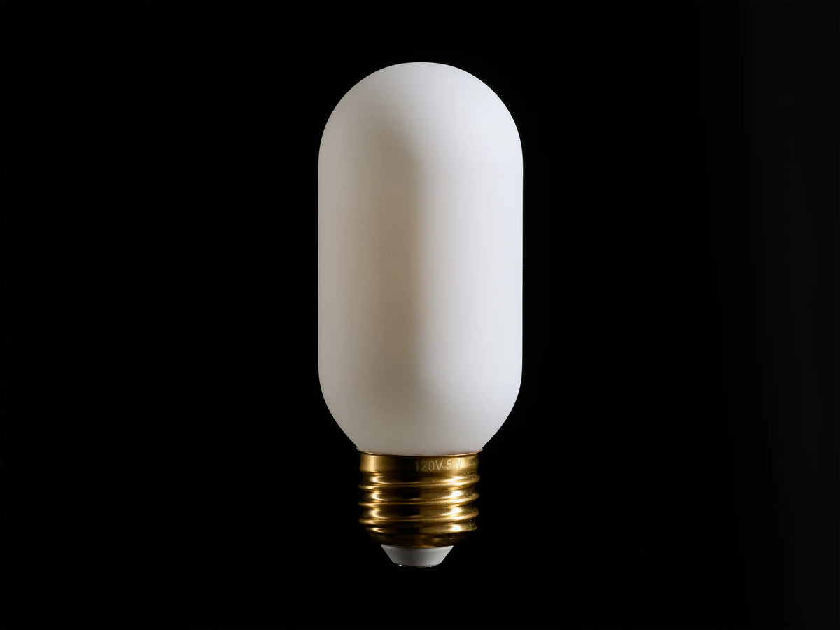 A white, cylindrical light bulb with a frosted surface and a brass screw base, centered against a black background.