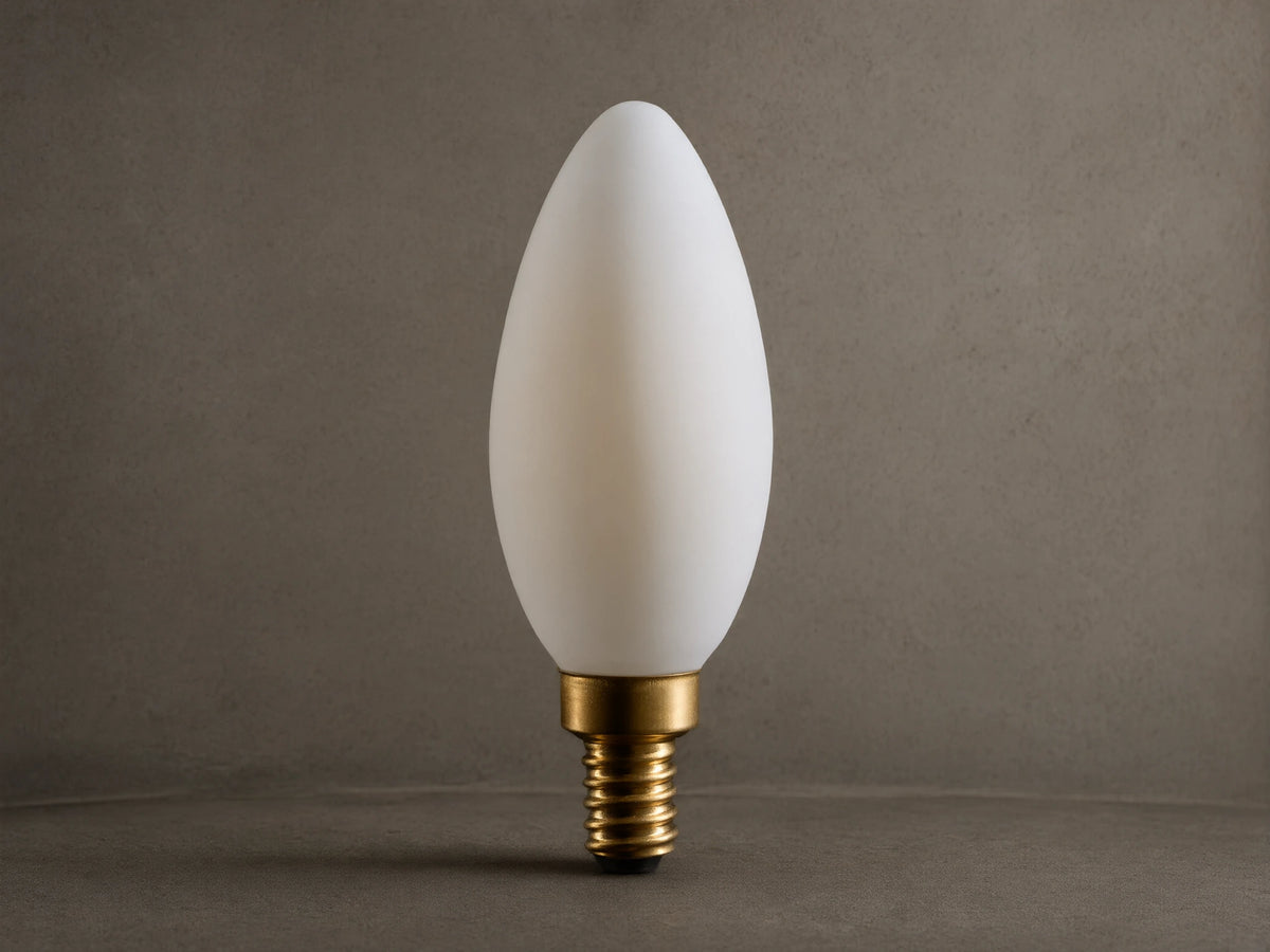 A white, teardrop-shaped LED bulb with a gold screw base, displayed against a black background.