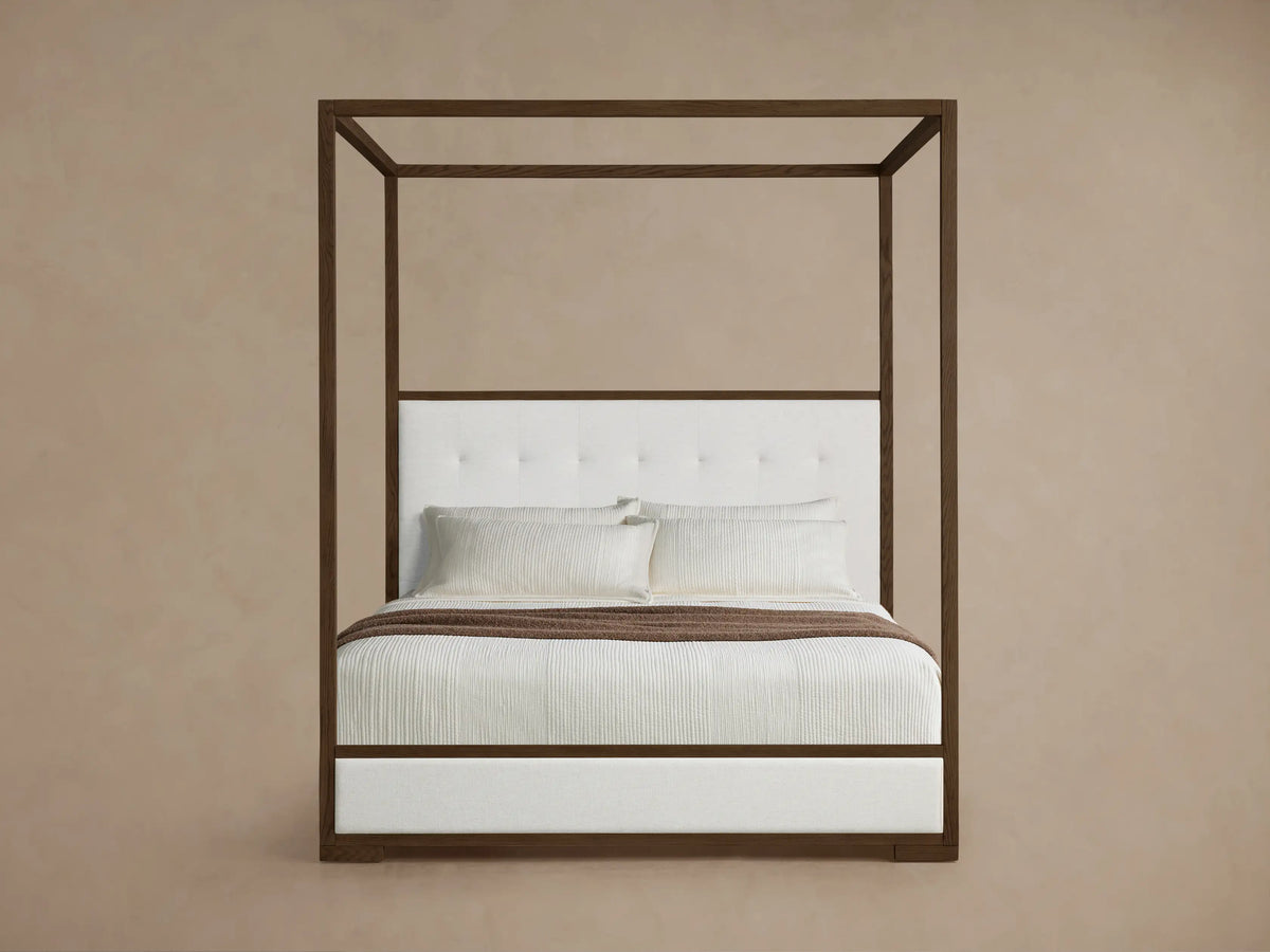 Front view of the Darien Box-Tufted Canopy Bed with dark wood frame, white box-tufted headboard, and white upholstered footboard.
