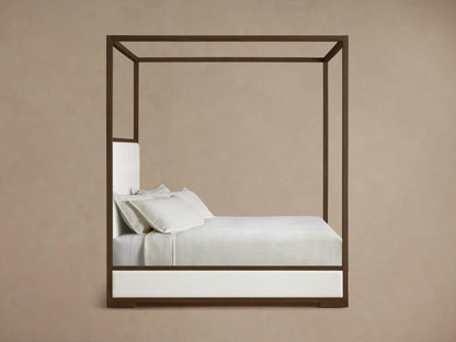 Side profile of the Darien Box-Tufted Canopy Bed, featuring a dark brown wood frame, white upholstered panels, and white bedding.