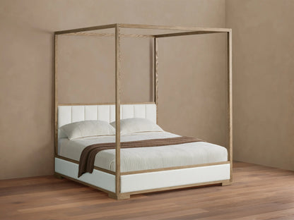 Darien Channel-Stitched Canopy Bed. Light oak frame, white channel-stitched headboard & base, light beige bedding with brown throw.