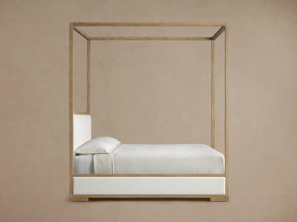 Close-up of Darien Channel-Stitched Canopy Bed, showing light oak wood frame and off-white channel-stitched upholstered headboard.