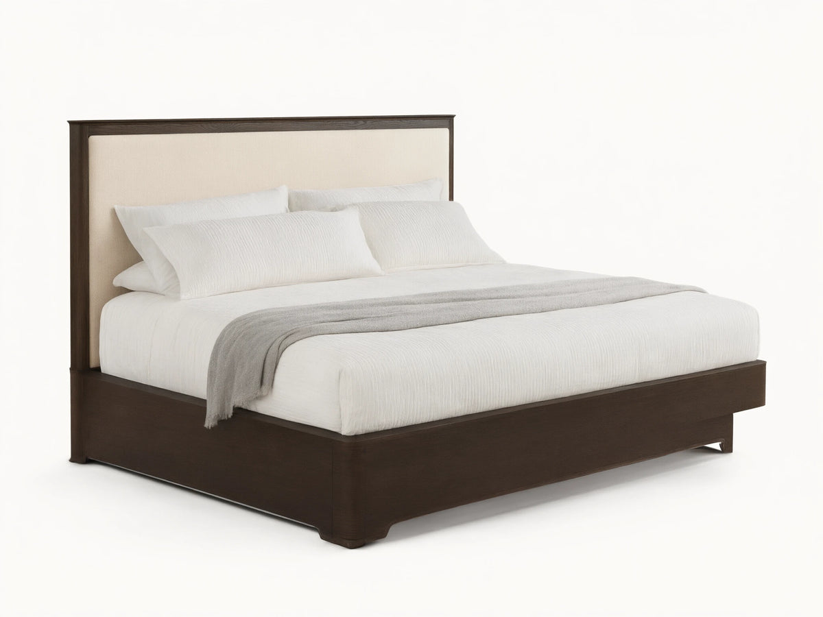 Conley Panel Bed with dark oak frame & cream upholstered headboard. Bed has white textured bedding & a gray throw blanket.