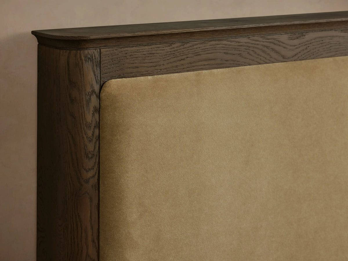 Conley Panel Bed with dark wood frame, tan fabric headboard, white textured bedding, and a light grey throw.