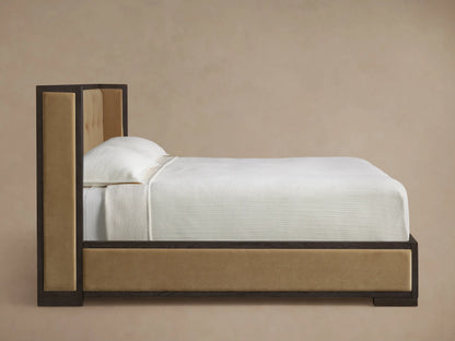 Darien Box-Tufted Shelter Bed. Angled close-up of dark oak frame and beige box-tufted upholstered headboard.
