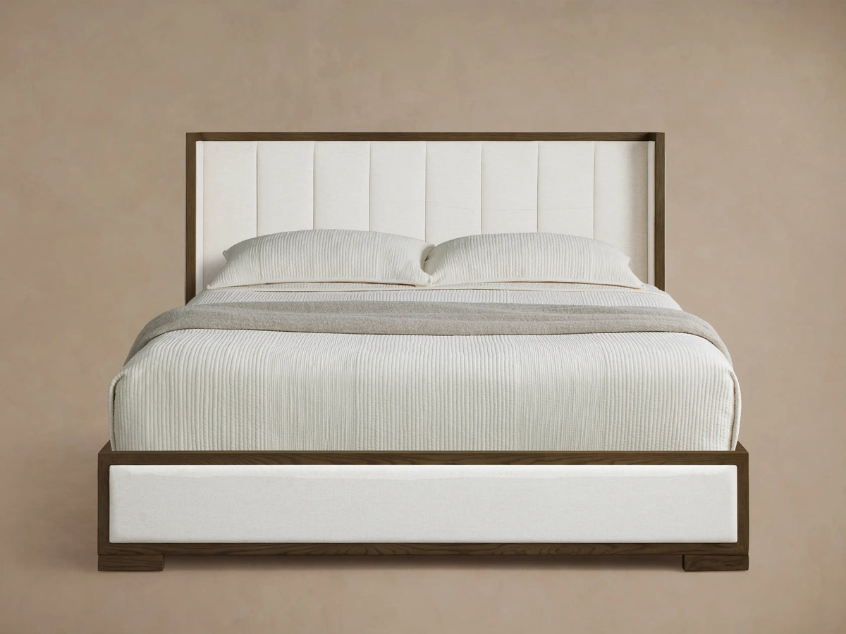 Front view of the Darien Channel-Stitched Shelter Bed with a brown wood frame, white channel-stitched upholstery, and white bedding.
