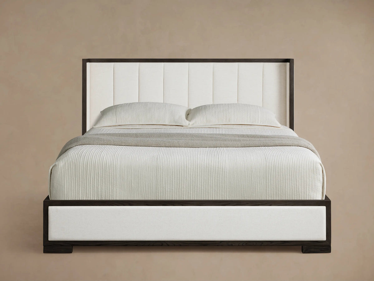 Darien Channel-Stitched Shelter Bed with dark wood frame & white channel-stitched upholstery, white bedding, grey throw.