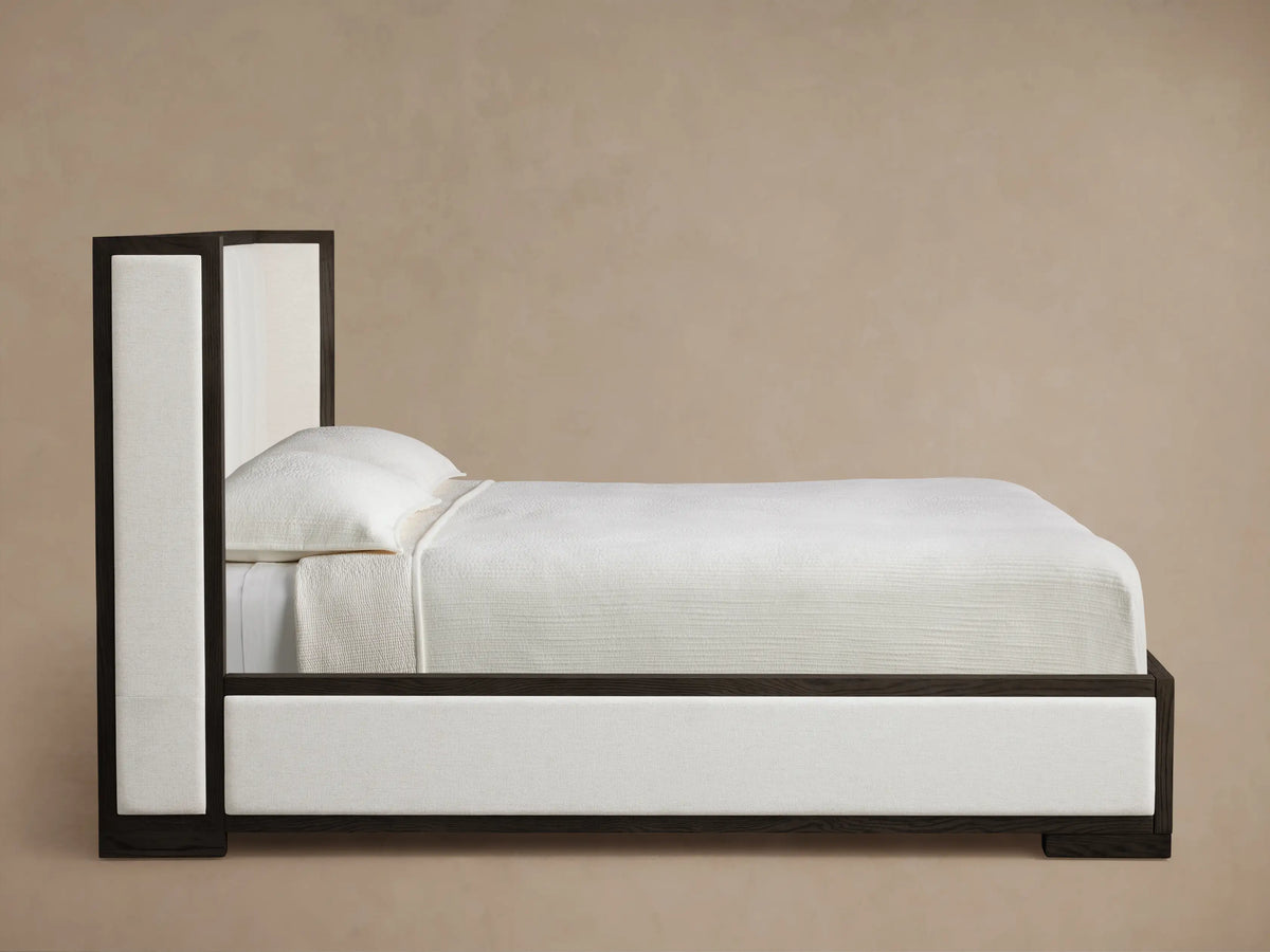 Angled close-up of Darien Channel-Stitched Shelter Bed; dark oak frame around light beige fabric panel & channel-stitched headboard.