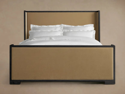 Darien Shelter Bed with high footboard, featuring oak frame and upholstered panels in a tan finish, white bedding visible.