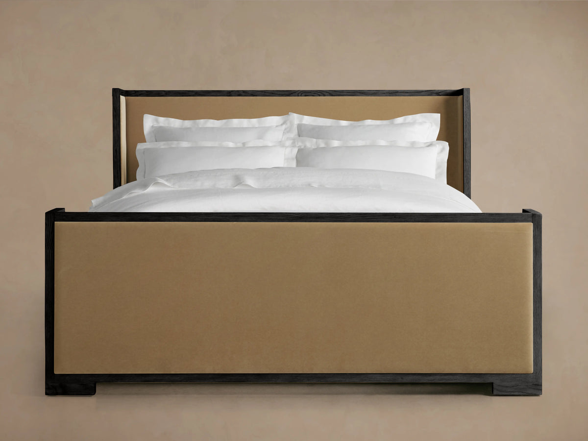 Darien Shelter Bed with a high footboard, oak frame, upholstered beige panels, white bedding, set against a neutral background.