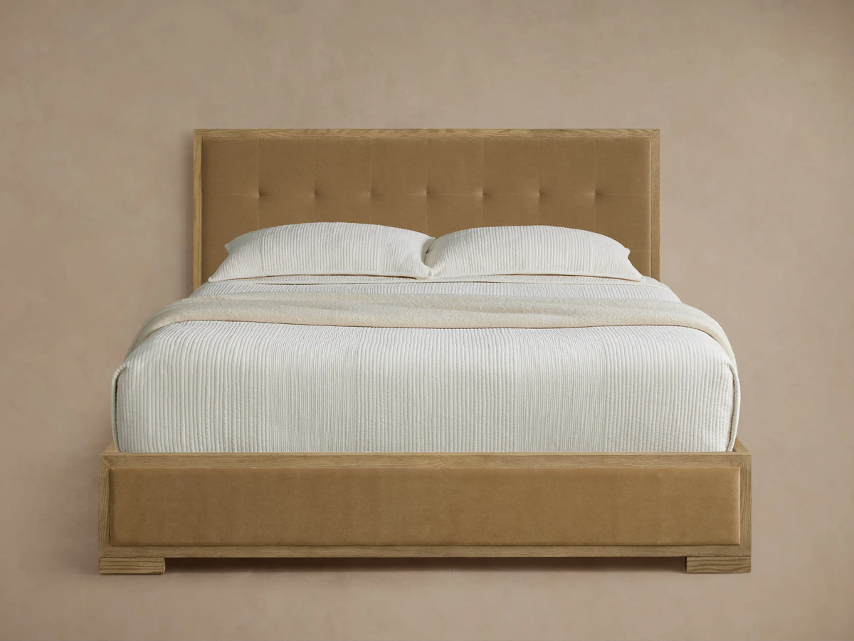 Darien Box-Tufted Panel Bed, light oak frame, tan box-tufted headboard & upholstered rails, white bedding, beige throw.