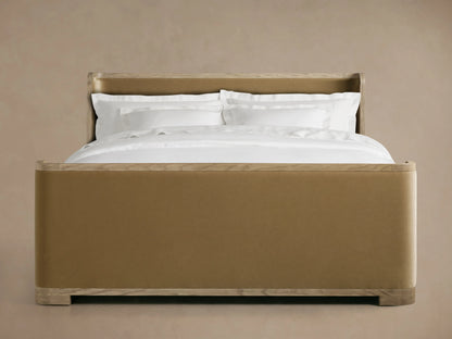 Darien Curved Shelter Bed in oak with high footboard, beige upholstered panels, white bedding, on wooden floor, side view.