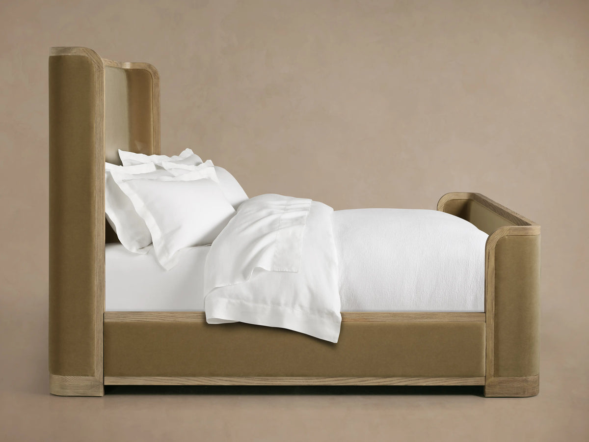 Darien Curved Shelter Bed with upholstered panels, oak frame, high footboard, and white bedding in a neutral setting.