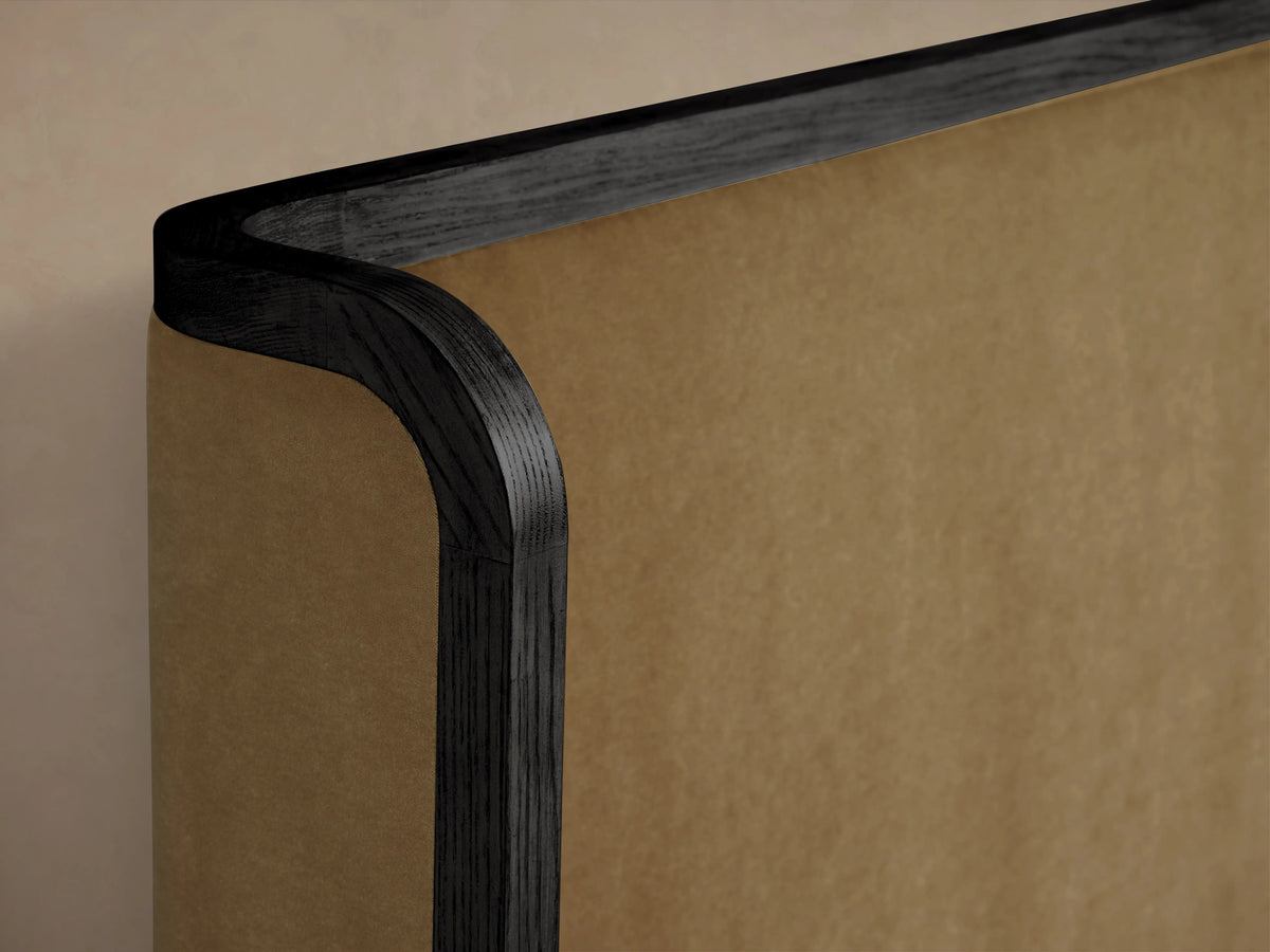 Curved corner of the Darien Curved Shelter Bed with High Footboard, displaying dark oak wood finish and tan upholstered panel.