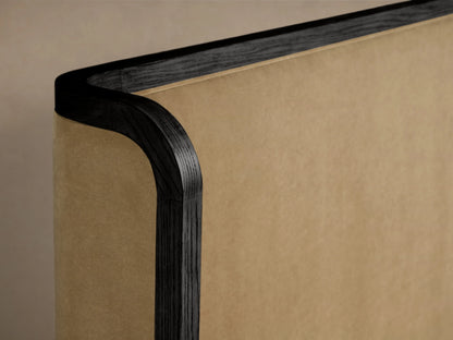 Darien Curved Shelter Bed featuring a high upholstered headboard and low footboard, in oak, with white bedding.