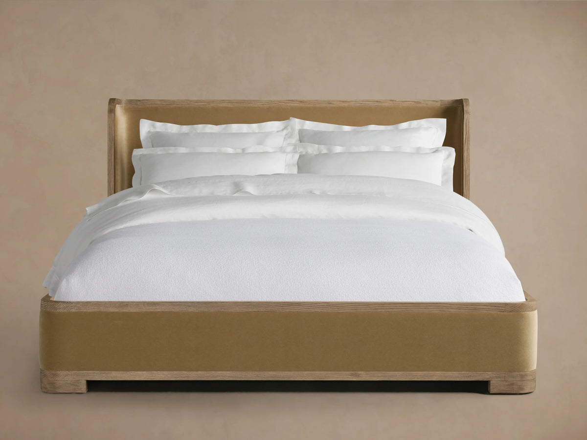 Darien Curved Shelter Bed features a high, curved headboard with oak wood and upholstered panels, low footboard, and white bedding.