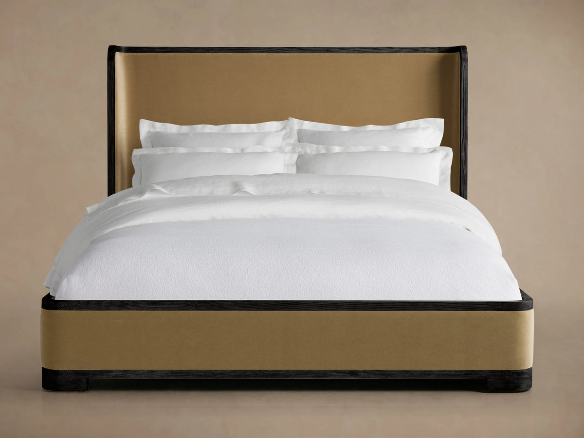 Darien Curved Shelter Bed with Low Footboard in oak veneer, featuring tall beige upholstered headboard and white bedding.