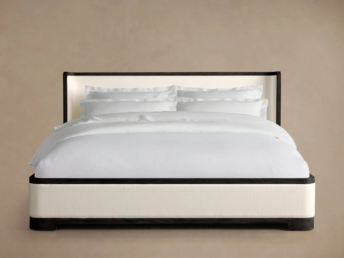 Darien Curved Shelter Bed with Low Footboard, featuring white bedding, dark oak frame, and upholstered panels on neutral background.