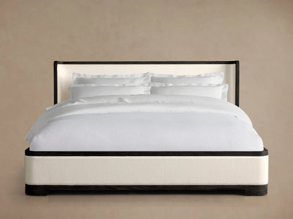 Darien Curved Shelter Bed with Low Footboard, featuring white bedding, dark oak frame, and upholstered panels on neutral background.